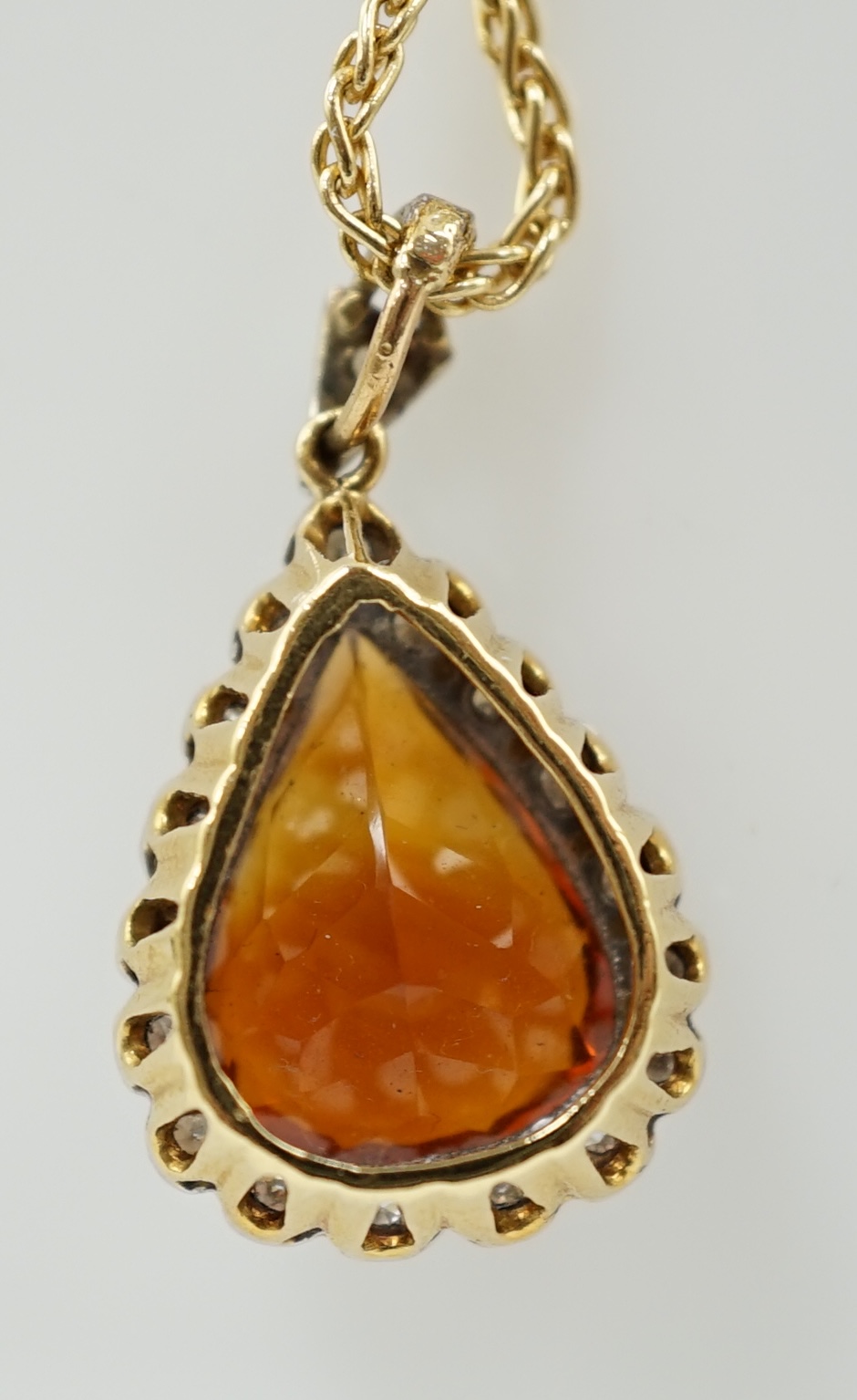 A recent 18k gold, platinum and single stone pear cut citrine pendant, with diamond chip border, on an 18ct gold fine link chain